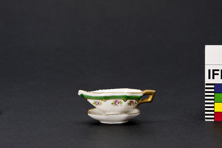 Gravy boat with gold, green and pink.