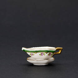 Gravy boat with gold, green and pink.
