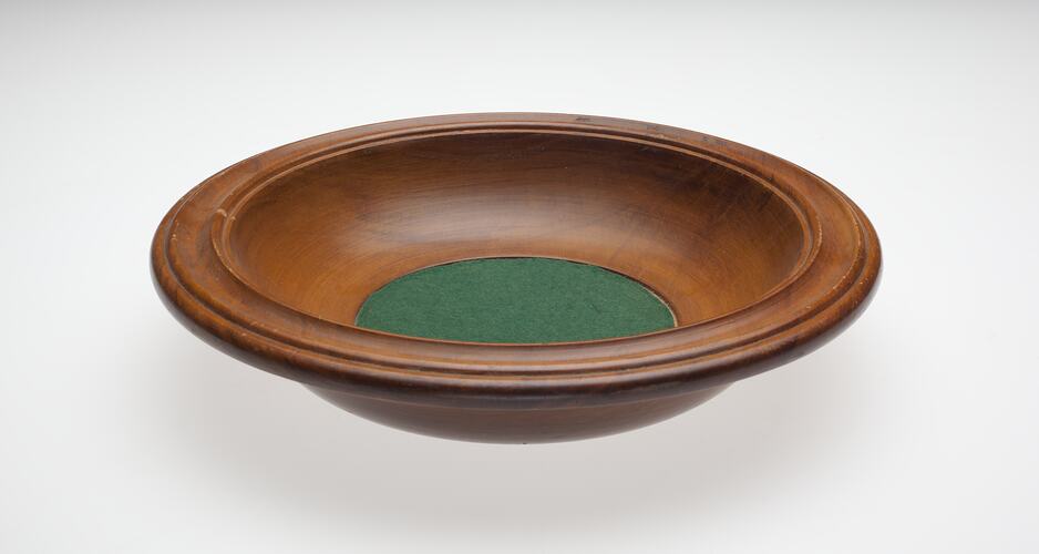 Wooden bowl with green felt bottom.