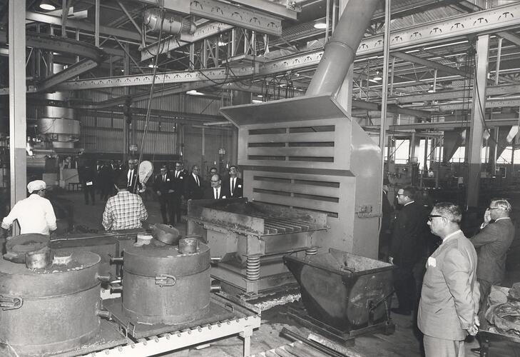 Men standing in factory foundry.