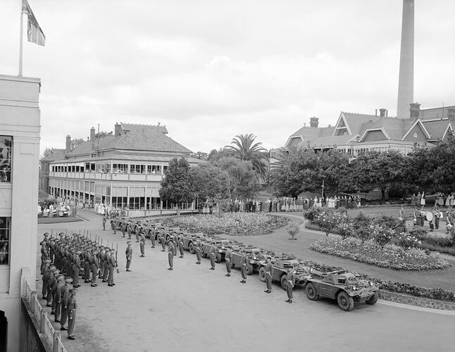 Military demonstration in courtyard at Heidelberg Hospital. Soldiers in formation and military vehicles at left and in centre. Patients and nurses watch the display.