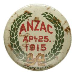 Badge with red printed text in centre within a green wreath on white background.