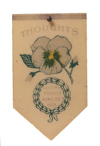 Cream coloured metal badge with image of flower and text.