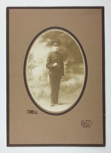 Studio portrait of man in military uniform with brown card border.