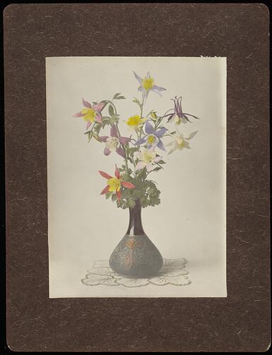 Still life of irises and other colourful flowers in vase.