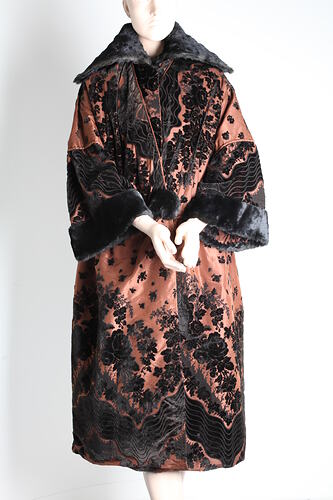 Brown silk coat with black velvet floral elements. Features large black fur collar and broad black cuffs.
