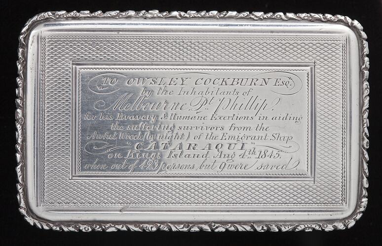 Decorative silver snuff box with engraved text.