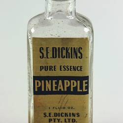 Glass bottle with red metal screw lid and label on side.