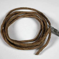 Coil of brown string made of paper.