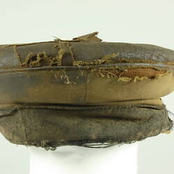 Rear view of old battered nightsoil collector's khaki flat top cap