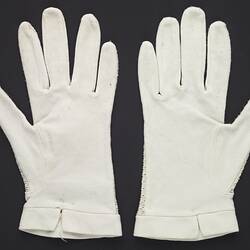 Wrist length white gloves. Palm side up.