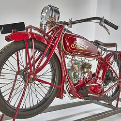 Red motor cycle with yellow lettering on tank. Left front view.