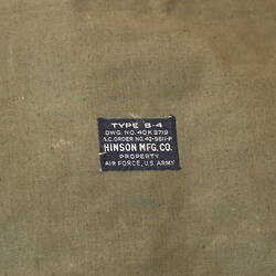 Detail of label on khaki canvas valise. Black label, white text.