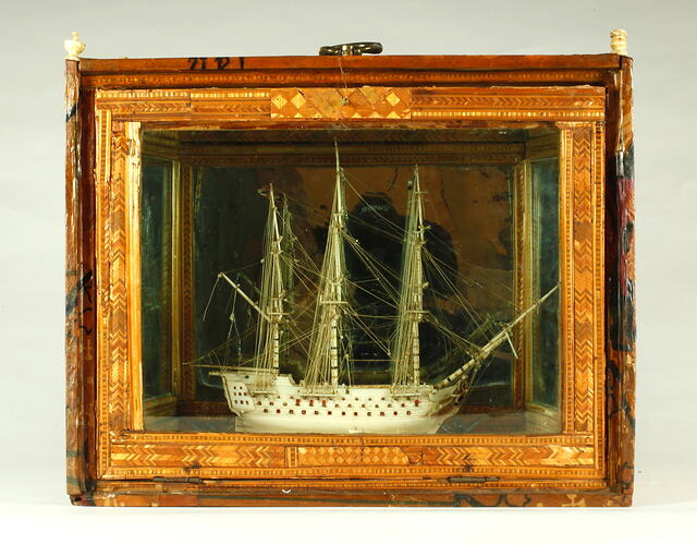 Model ship inside a decorative box.