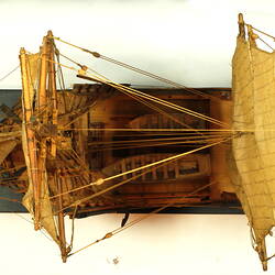 Wooden ship with three masts, overhead view.