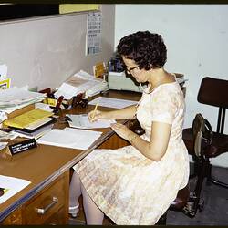 Slide - Kodak Australasia Pty Ltd, Woman Writing at Desk, Rockhampton, Apr 1970