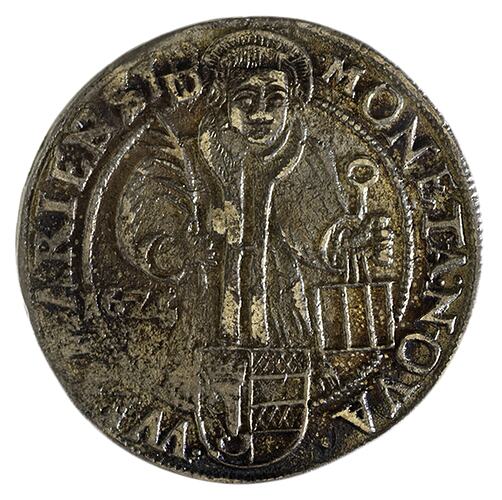 Round medal with saint holding bible and palm branch, facing, shown half-length above a Shield of Arms. Text a