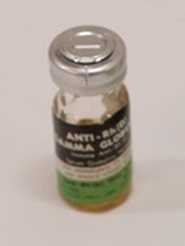 Glass vial with black, green and white label. Silver top.