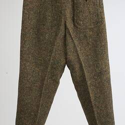 Back of brown trousers with three buttons at waistline. Central fastening strap. Right side pocket.