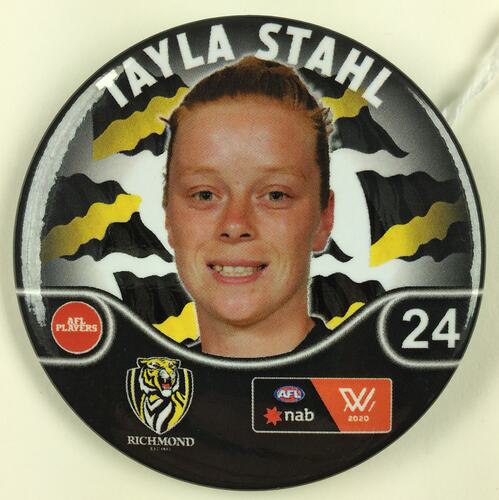 Metal round badge with black, white and yellow. Has woman's smiling face in colour, tiger and number 24.