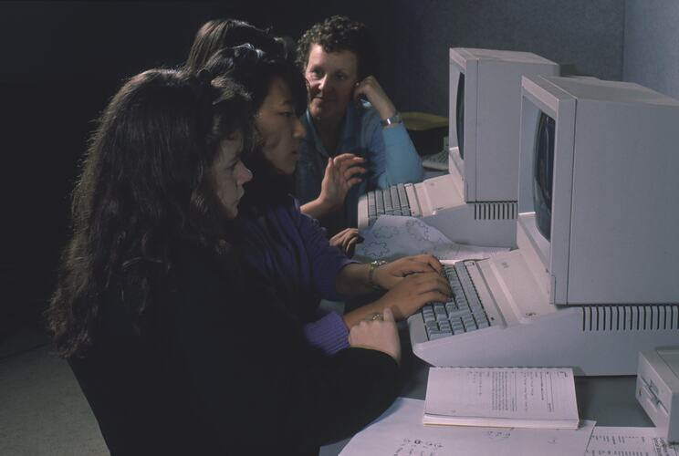 A row of computers being used by students.