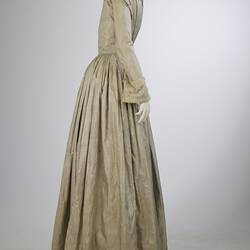 Pale grey striped silk dress with long sleeves and long skirt. Right profile.