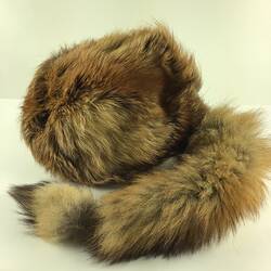 Grey furry cap with racoon like tail.