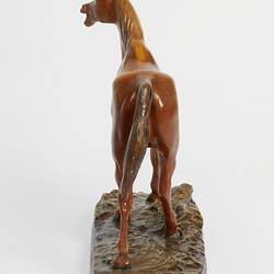 Plaster moulded, hand painted brown horse with a black base. Rear view.