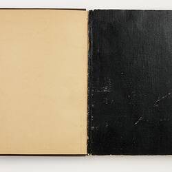 Open book with off white ruled page on left side. Brown back cover on right side.