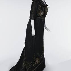 Black, silk satin dress, beading, floral embroidery. Profile.