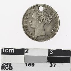 Round silver coloured medal with profile of woman and text surrounding.