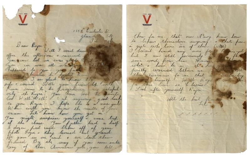 Handwritten letter on lined paper with red V logo at top, paper has brown stains from water damage.