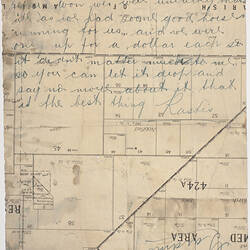 Reverse of handwritten letter. Cursive script in blue ink over printed lines and text of a town plan.