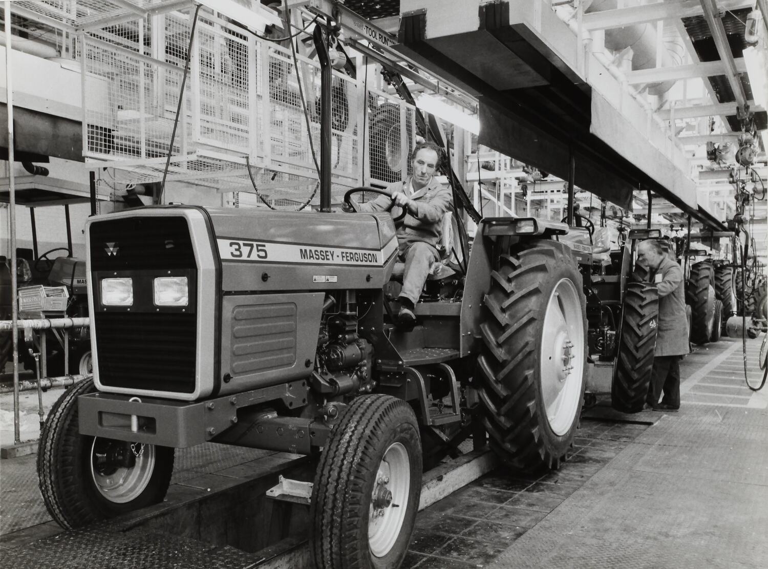 Photograph Massey Ferguson, Worker Driving MF375 Tractor off