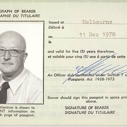 Passport, white pages and black print, blue signature, black and white photograph of a man.