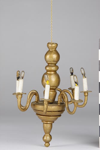 Gold coloured chandelier with electric bulbs.