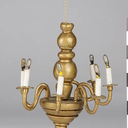 Gold coloured chandelier with electric bulbs.