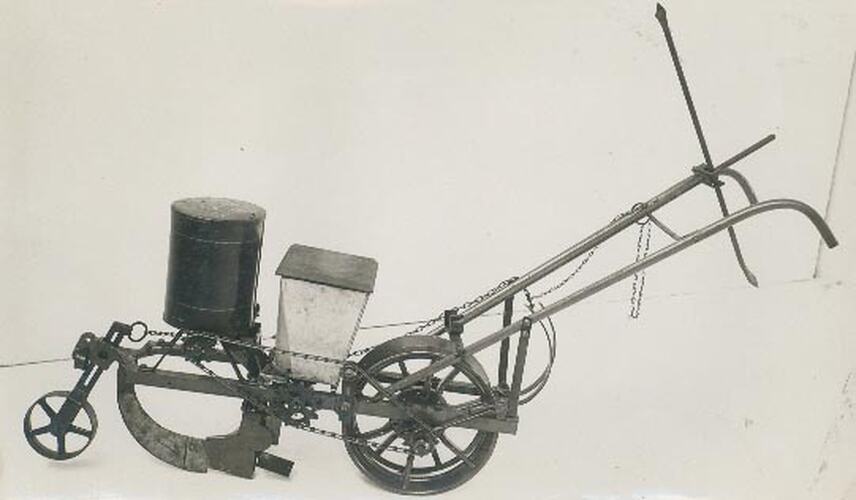 Left hand side view of a studio photograph of a one horse single row seed planter.