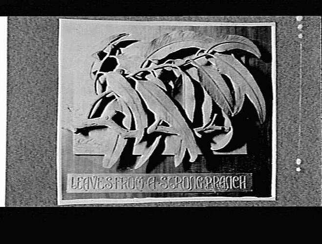 Wood carving of branch with leaves.