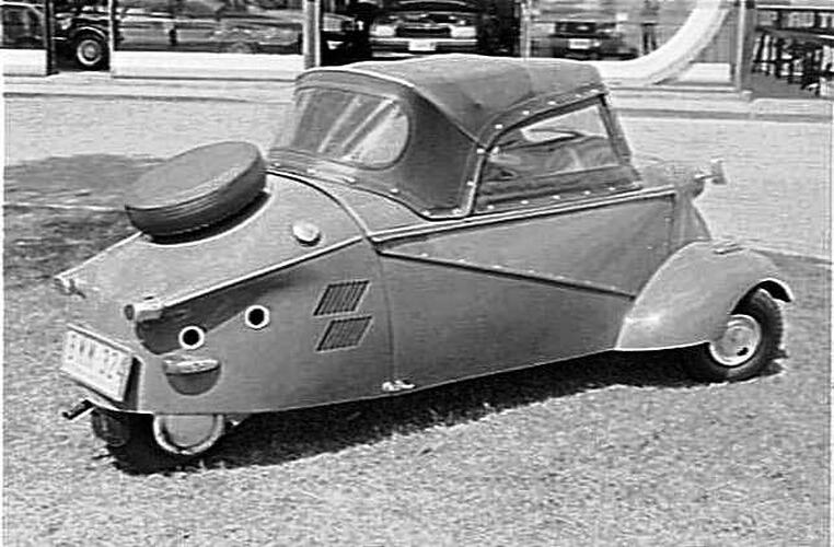 Black and white photograph of a 3-wheel motor car.