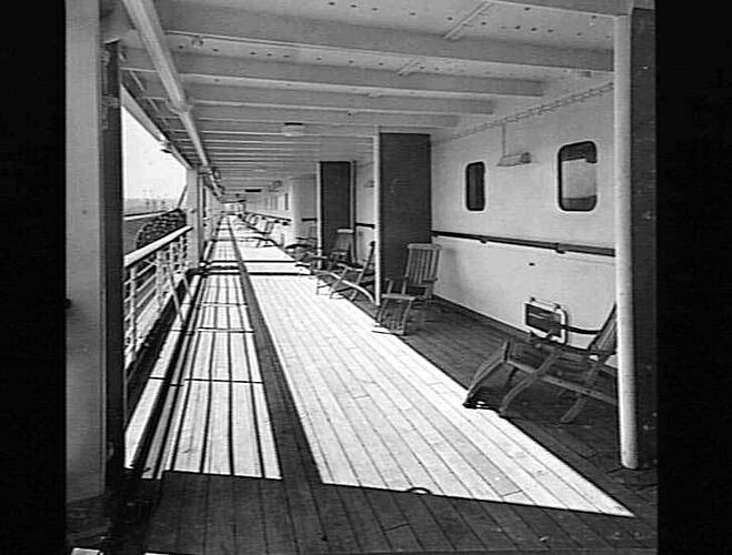 Ship deck. Deck chairs at right.