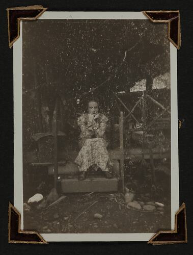 Woman in dress sitting on steps.
