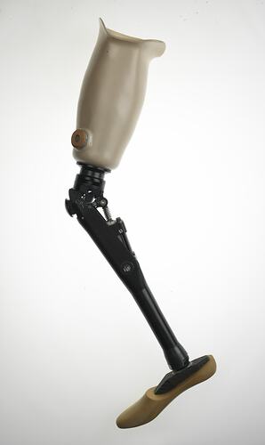 Metal, carbon fibre and plastic leg with skin coloured socket to knee and black carbon fibre shin. Knee bends to approximately 100 degrees.