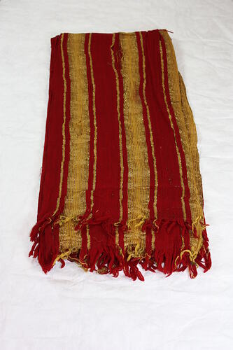 Large rectangular scarf striped red and yellow with gold thread fabric, fringed at the end.