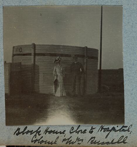 Man and woman standing in front of a small round metal building.
