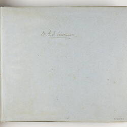 Inside page of photo album with hand-written name.