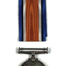 Round silver medal with man's head in profile and blue, black, white and orange ribbon.