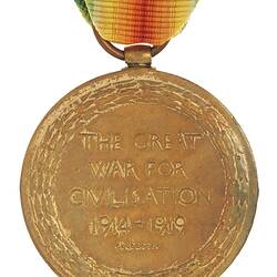 Round medal with decorative wreath encircling text. Suspended from multi-coloured ribbon.