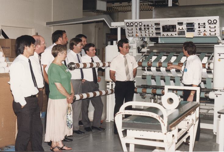 Two men demonstrating large machine to group.