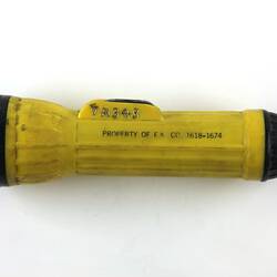 Yellow and black torch with engraved text.